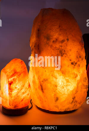 Große Himalaya Salz Lampen leuchten gegen einfachen Hintergrund in dunklen Zimmer Stockfoto