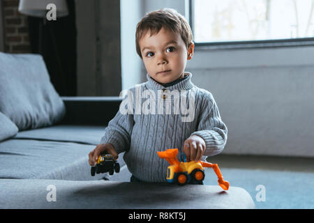 Freudige kleinen Jungen spielen mit Spielzeug Autos im Wohnzimmer zu Hause Stockfoto