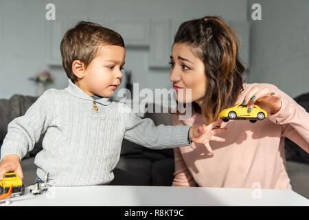 Kleinen Sohn und seine Mutter spielen mit Spielzeug Autos zu Hause Stockfoto