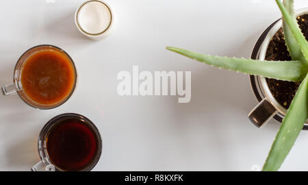 Blick von oben auf die Kaffeetassen und Anlage in eine Kaffeetasse Pflanzmaschine auf einem weißen Tisch mit Platz kopieren Stockfoto