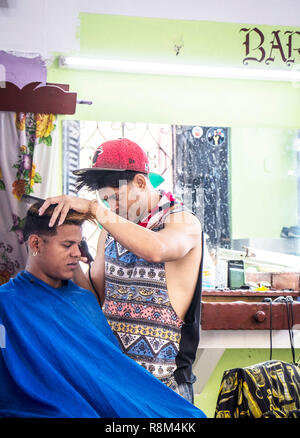 Jungen kubanischen Friseur geben Mann Haarschnitt und eine Rasur in Havanna, Kuba Stockfoto