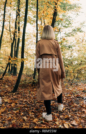 Zurück Blick auf Frau Wandern im Herbst Wald Stockfoto