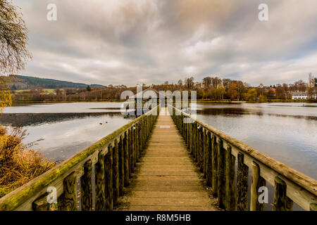 Bild eines Holz- Weg zu einem Pavillon in der Mitte des Doyards See mit schönen Reflexion in Vielsalm in den Belgischen Ardennen Stockfoto