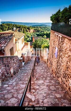 Ansicht in einer Gasse in Roussillon Frankreich mit einer Dame bewundern die schöne Ockerfarben und Landschaft der Provence in der Ferne. Stockfoto