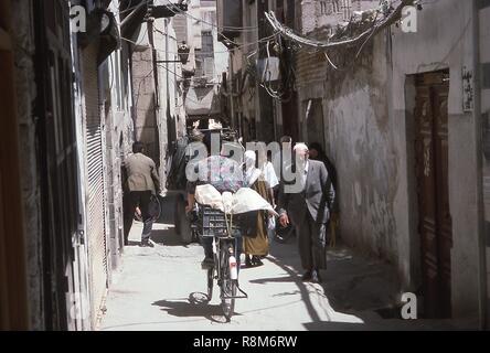 Szene einer engen Gasse mit Fußgängern und Radfahrern, in Damaskus, Syrien, Juni, 1994 voll. () Stockfoto