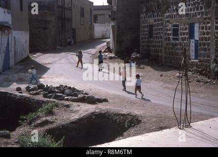 Szene der Kinder spielen Fußball (Fußball) auf einer staubigen Straße in Qalaat al-Madiq, Syrien, Juni, 1994. () Stockfoto