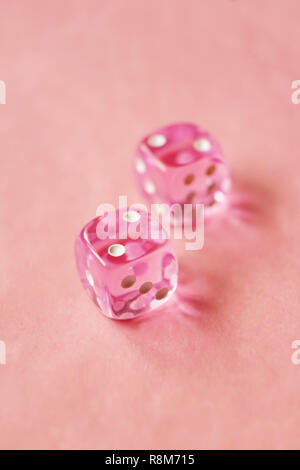 Eine lebendige monochromatischen Makro mit Tiefenschärfe über zwei pink Glas Würfel mit zwei unglücklichen Nummer zwei auf rosa Hintergrund. Stockfoto