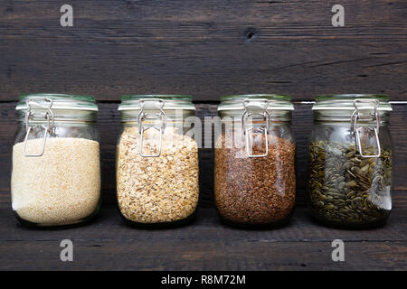 Verschiedene Samen in storage jars in der Speisekammer, dunklen Hintergrund. Smart Küche Organisation Stockfoto