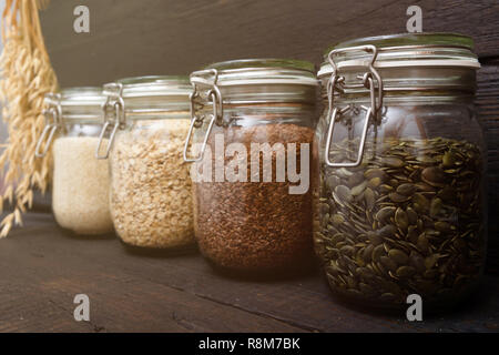 Verschiedene Samen in storage jars in der Speisekammer, dunklen Hintergrund. Smart Küche Organisation Stockfoto