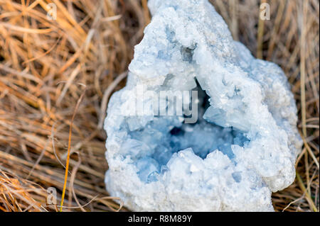 Nahaufnahme eines Celestine Geode Crystal mit in das Gras bei Sonnenuntergang Stockfoto