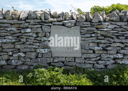 Eine neu restaurierte Trockenmauer mit der Inschrift "Held by Gravity" auf der Isle of Purbeck, Dorset, England, UK Stockfoto