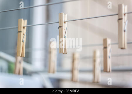 Hölzerne Wäscheklammern auf einer Wäscheleine, Blur, Licht Foto. Das Konzept der eco-Verbrauch, die Verwendung von natürlichen Materialien, Bewusstsein. Stockfoto