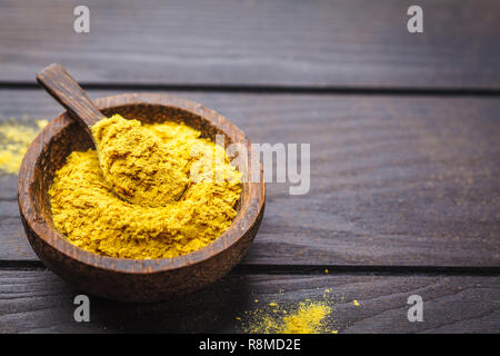 Ernährung Hefe in eine hölzerne Schüssel, Platz kopieren, dunklen Hintergrund, kopieren. Gesunde vegane Ernährung Konzept. Stockfoto