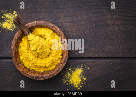 Ernährung Hefe in eine hölzerne Schüssel, Platz kopieren, dunklen Hintergrund, kopieren. Gesunde vegane Ernährung Konzept. Stockfoto