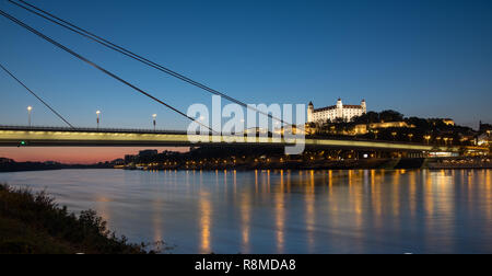 Am Abend Blick auf die Skyline von Bratislava vom Ufer der Donau. Blick auf den UFO-Brücke, das Schloss und die Altstadt. Stockfoto