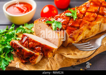 Gebackene Fleischkäse mit Gruenen und Barbecue Sauce auf einem Holzbrett. Amerikanische Küche Konzept. Stockfoto