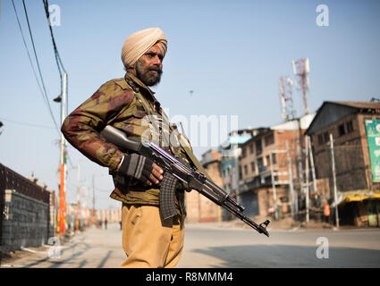 (181216) - SRINAGAR, Dez. 16, 2018 (Xinhua) - Ein indischer paramilitärischen Trooper wacht während der Beschränkung in der Innenstadt von Srinagar, die Hauptstadt des Indischen-kontrollierten Kaschmir, Dez. 16, 2018. Beschränkungen durch Behörden und die Abschaltung von separatisten am Sonntag verhängt normales Leben in unruhigen Indischen Hit - Kaschmir gesteuert, sagten Beamte. Am Samstag, den drei Kämpfer und ein trooper wurden in heftigen Schießerei in einem Dorf getötet und anschließend sieben Zivilisten wurden getötet und mehr als zwei Dutzend in Auseinandersetzungen verletzt. (Xinhua / Javed dar) Stockfoto