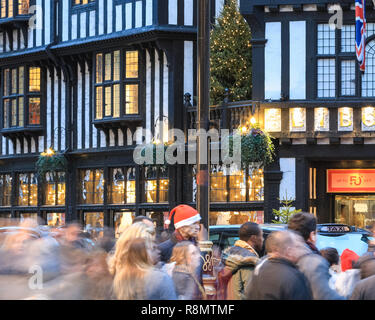 London, Großbritannien. 16. Dez 2018. Käufer eilig die Vergangenheit des Liberty speichern, aber ein Mann in einem Santa Hut dauert einen Moment in der Mitte des Shopping Rush zu ruhen. Auf einer der verkehrsreichsten Wochenenden vor Weihnachten, Massen von Käufern Spaziergang entlang der Regent Street mit ihren vielen bunten Fenster wird angezeigt. Credit: Imageplotter Nachrichten und Sport/Alamy leben Nachrichten Stockfoto