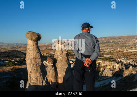 Ein Mann gesehen neben der Drei Grazien Felsformation in Kappadokien, Türkei. Kappadokien in der Türkei ist wie das Land der schönen Pferde im Herzen der anatolischen Türkei bekannt. Stockfoto