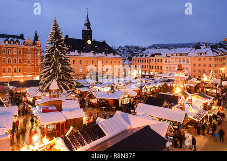 Annaberg Buchholz, Deutschland. 14 Dez, 2018. Die Stände, Pyramide und Weihnachtsbaum an der Annaberger Weihnachtsmarkt sind in Schnee bedeckt. Der große Markt Pyramide sagt Stadt, im Bergbau und in der Weihnachtsgeschichte. Auf dem Markt gibt es Original Erzgebirge Holz Kunst in traditionellem und modernem Design. Räucherkerzen, weihnachtliche Düfte, Annaberger Faltsterne, mehr als 80 eingerichtete Stände sowie stimmungsvolle Advents- und Weihnachtszeit Musik Atmosphäre bieten. Kredite: Jan Woitas/dpa-Zentralbild/dpa/Alamy leben Nachrichten Stockfoto