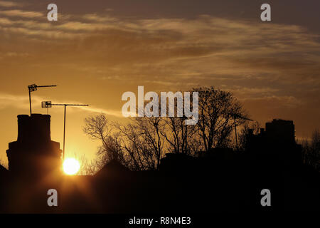 London, Großbritannien. 17 Dez, 2018. Winter goldene Sonne über North London erstellen Silhouette der Schornstein, Bäume und Dächer. Credit: Dinendra Haria/Alamy leben Nachrichten Stockfoto