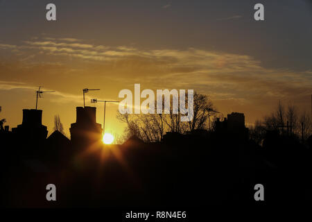 London, Großbritannien. 17 Dez, 2018. Winter goldene Sonne über North London erstellen Silhouette der Schornstein, Bäume und Dächer. Credit: Dinendra Haria/Alamy leben Nachrichten Stockfoto