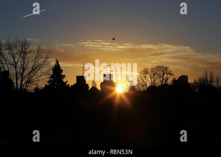 London, Großbritannien. 17 Dez, 2018. Silhouette der Schornstein, Bäume und Dächer sind während eines gesehen. Winter goldene Sonne über in London. Credit: Dinendra Haria/SOPA Images/ZUMA Draht/Alamy leben Nachrichten Stockfoto