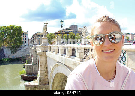 Junge, glückliche Frau auf einer Brücke in Rom Stockfoto