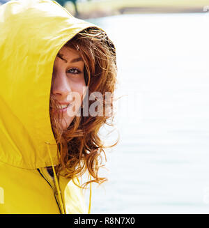 Portrait einer jungen Frau in einem gelben Regenmantel Stockfoto