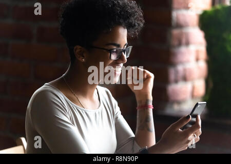 Glückliche afroamerikanische Frau mit Phone, feiern Gute Nachrichten Stockfoto