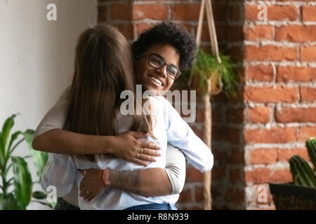 Lächelnd afrikanische amerikanische Frau mit Freundin umarmen Stockfoto