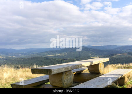 Holzbank und Berglandschaft im Hintergrund, niemand. Die schlesischen Beskiden, Polen. Stockfoto