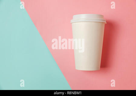 Einfach flach design Papier Kaffeetasse auf blau rosa Pastell farbenfrohen trendigen Hintergrund. Takeaway drink Container. Guten Morgen aufwachen wach Konzept. Stockfoto