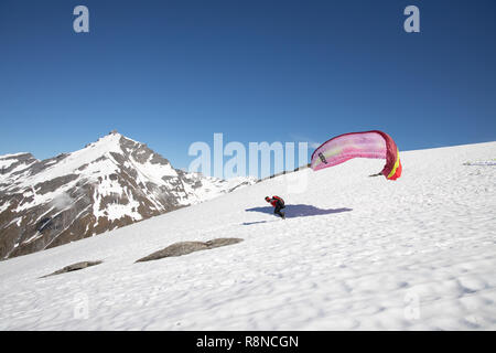 Gleitschirm starten aus schneebedeckten Bergen, Neuseeland Stockfoto