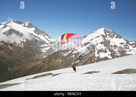 Gleitschirm starten aus schneebedeckten Bergen, Neuseeland Stockfoto