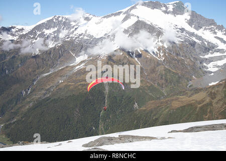 Gleitschirm starten aus schneebedeckten Bergen, Neuseeland Stockfoto