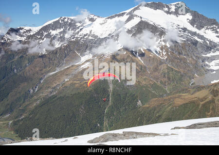 Gleitschirm starten aus schneebedeckten Bergen, Neuseeland Stockfoto