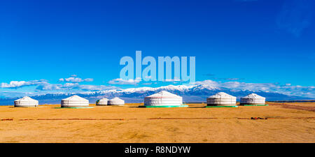 Panoramablick auf mongolischen Ger auf einem großen Steppe mit der schneebedeckte Berg im Hintergrund bei der Stadt Chowd in der Mongolei Stockfoto