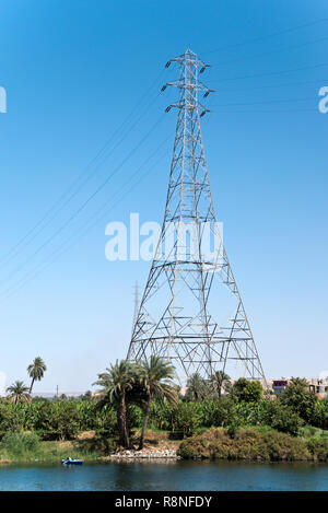Hohe Spannung elektrische Stromleitungen auf hohen Türmen über den Nil in Gebel el-Silsila, in der Nähe von Aswan, Ägypten. Stockfoto