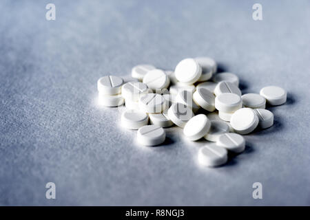 Weiße Pillen Tabletten auf einem grauen Oberfläche Nahaufnahme Stockfoto