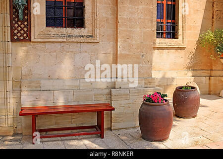 Sitzbank und Wein Schüsseln mit Blumen in der Nähe der Cana griechische orthodoxe Kirche Hochzeit in Kana in Galiläa, Kfar Kana, Israel Stockfoto