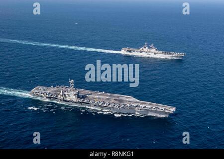 Die US Navy Flugzeugträger der Nimitz-Klasse USS John C Stennis, front, Segel, die sich in der Ausbildung mit der Amphibisches Schiff USS Essex während Patrol 14. Dezember 2018 in das Arabische Meer. Stockfoto