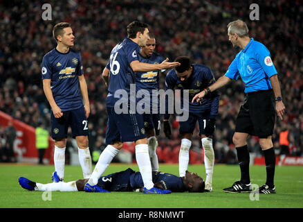 Von Manchester United Eric Bailly (Mitte) liegt auf der Steigung wie Ander Herrera (links) und Matteo Darmian (Mitte) sprechen mit Match Schiedsrichter Martin Atkinson (rechts) während der Premier League Match in Liverpool, Liverpool verletzt. Stockfoto