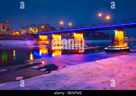 Uschhorod, Ukraine - Dec 26, 2016: Fußgängerbrücke über den Fluss Uzh bei Nacht. schöne Stadtbild der alten europäischen Stadt Uzhgorod im Winter Stockfoto