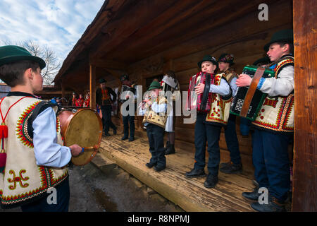 Uschhorod, Ukraine - Jan 13, 2018: Vasylya Festival im Museum der Volksarchitektur und Leben. Gruppe von Kindern in den traditionellen Farben singen Hütte Stockfoto