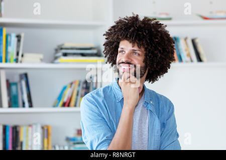 Denken hipster Mann mit afro Haar indoor zu Hause Stockfoto