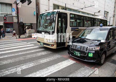 Bus und Taxi an einer Kreuzung in der Nähe von Shibuya in Tokio warten Stockfoto