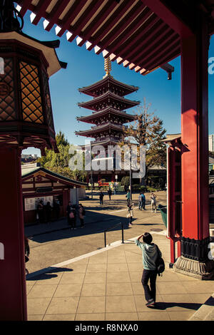 Eine Frau schaut oben an der Sensō-ji Tempel Pagode in Tokio. Stockfoto