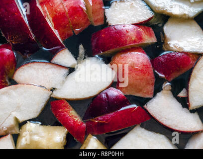 Bunte Apfelscheiben, Gemischte Früchte in einem Topf. Erfrischende Frucht Apfelwein Punsch Party Trinken. Organische Lebensmittel und Getränke Hintergrund. Stockfoto