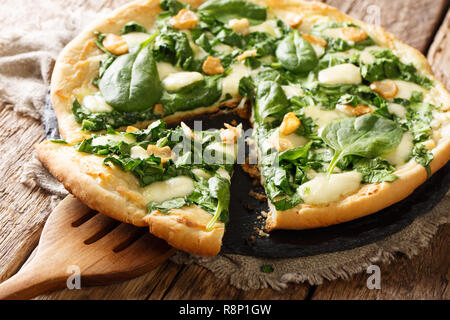 Gesunde weisse Pizza mit Spinat, Knoblauch und ricotta Käse und mozzarella Close-up auf dem Tisch. Horizontale Stockfoto